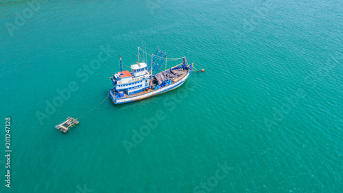 Fishing boat floating in the sea. The beautiful bright blue water in a clear day.Aerial view.Top view.