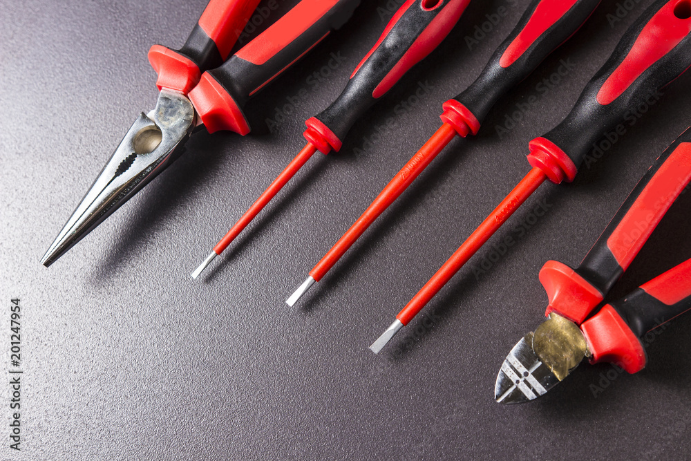 Tools electrician screwdrivers, pliers, platypuses on black background. Tools electrician screwdrivers, pliers, platypuses on black background.