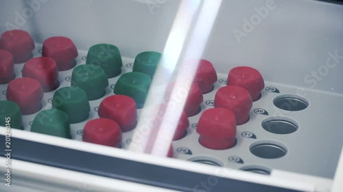 Laboratory shaker loaded with substances. Clip. Substances in flasks on a shaker for experiment photo