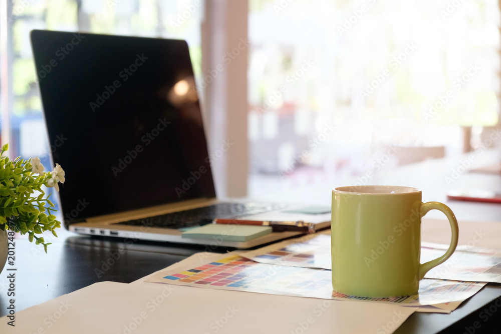 Cup of coffee on creative workplace with green mug a coffee break and coffee time concept.