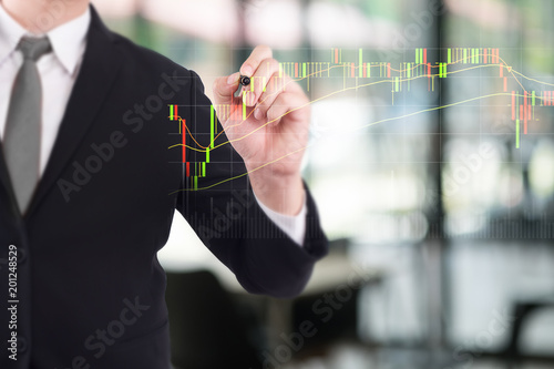 Business person touching finance stock charts and diagrams with pen analyzing data.