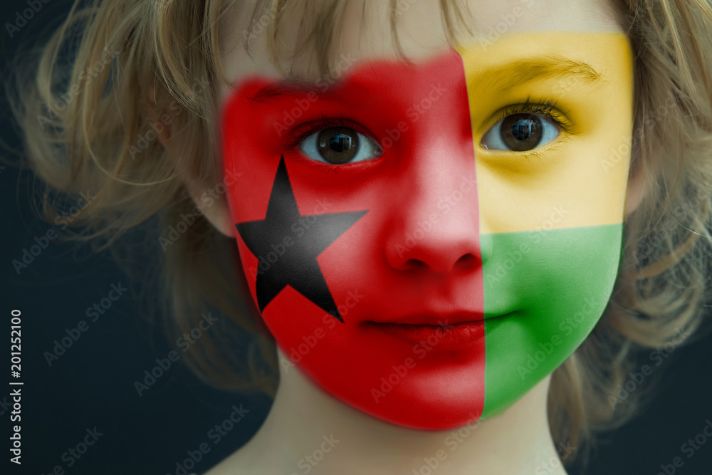 Child with a painted flag of Guinea Bissau
