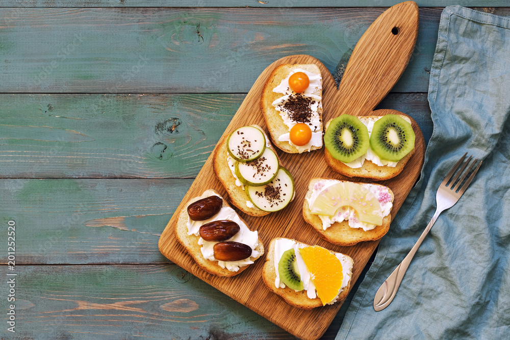 Sweet sandwiches on an old green wooden table, top view, copy space. Fruit sandwiches on a cutting board. Sweet sandwiches on an old green wooden table, top view, copy space. Fruit sandwiches on a cutting board.