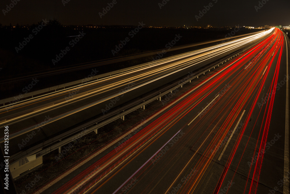 Φωτογραφία Motion blurred light tracks glowing to the darkness of highway traffic to the city just after sunset
