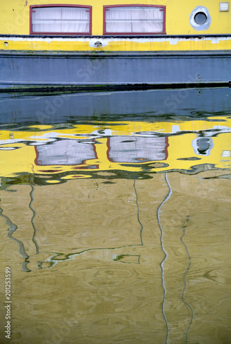 reflection of a yellow boat in the London canal, photo