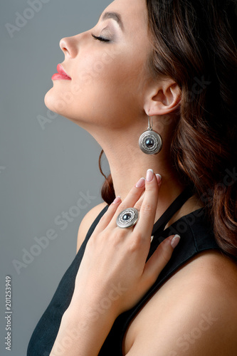 portrait of beautiful woman with long hair wearing stylish silver Jewelery. Necklace and earring on human model isolated on white