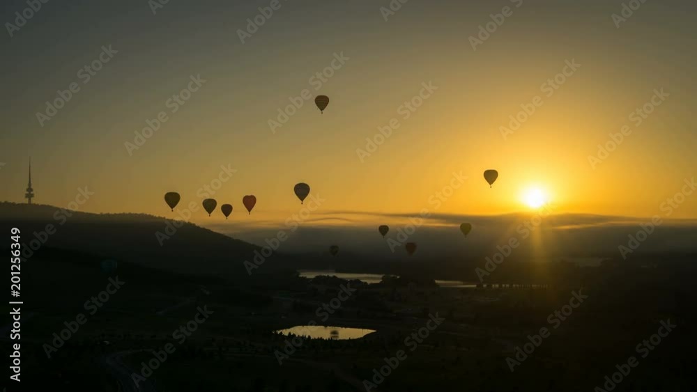 Silhouette time lapse of hot air balloons at sunrise flying high above Canberra, Australia. Silhouette time lapse of hot air balloons at sunrise flying high above Canberra, Australia.