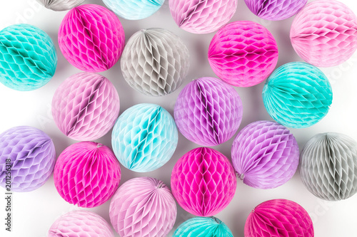 Honeycomb balls decorations background. Pink, lilac and turquoise paper pom pom. Flat lay. Holiday concept