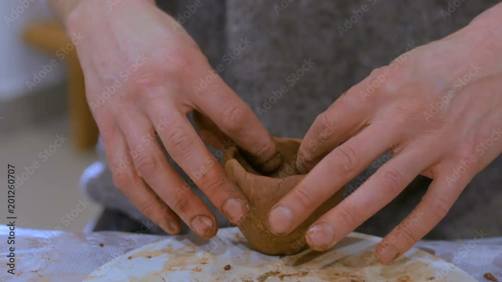 Professional male potter making clay mug in pottery workshop, studio. Handmade, art and handicraft concept Professional male potter making clay mug in pottery workshop, studio. Handmade, art and handicraft concept