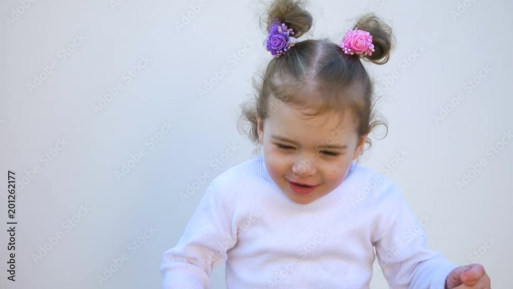 A cute little baby girl is looking into the camera and coughs A cute little baby girl is looking into the camera and coughs