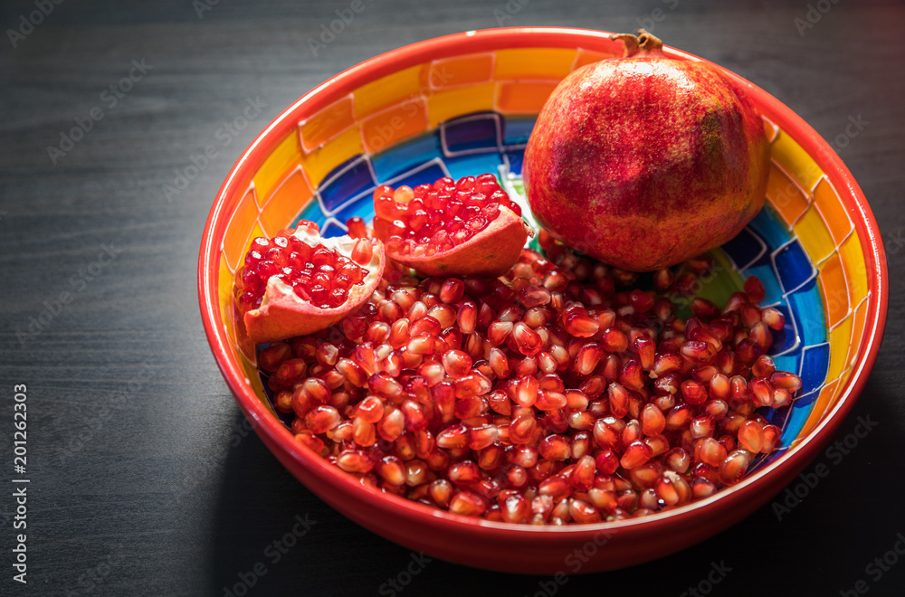 Ripe pomegranate fruit in a jar on wooden vintage background Ripe pomegranate fruit in a jar on wooden vintage background