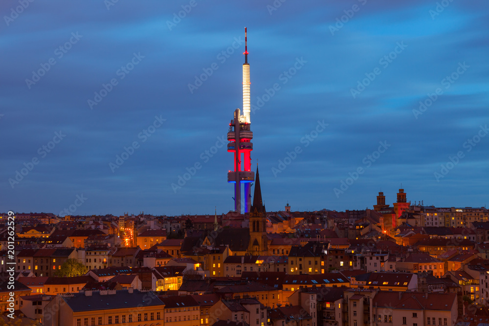 Zizkov Television Tower (circa 1992) in Prague and roof top view of dwellings around tower. Night view.