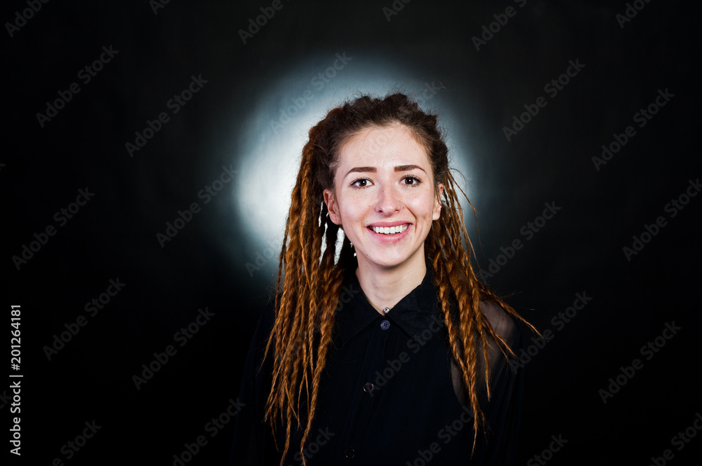 Fototapeta premium Studio shoot of girl in black with dreads at black background with nimbus.