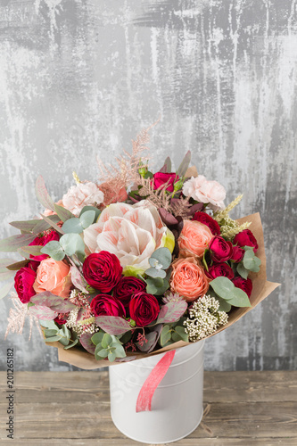 Fototapeta Naklejka Na Ścianę i Meble -  Close-up Beautiful Bouquet. Spring flowers on gray background. flower shop. Wooden table. Vertical photo