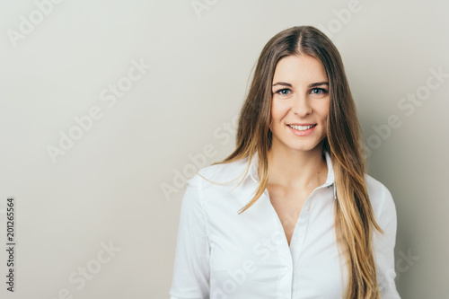 Portrait of young smiling woman in white shirt