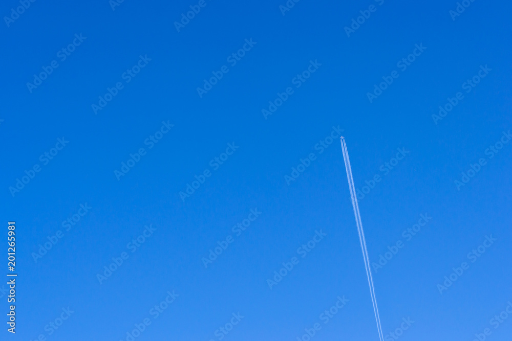 Steam trace of the aircraft against the blue sky. Airplane vapour trails. Industrial and civil air transport. Passenger plane takes off from Pulkovo airport, St. Petersburg, Russia Steam trace of the aircraft against the blue sky. Airplane vapour trails. Industrial and civil air transport. Passenger plane takes off from Pulkovo airport, St. Petersburg, Russia