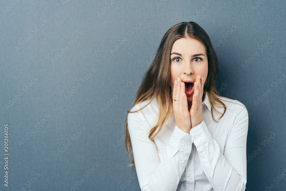 Shocked young woman exclaiming in surprise Shocked young woman exclaiming in surprise