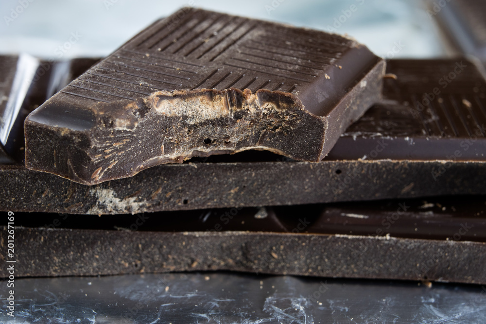 Black chocolate cubes broken and stacked on each other. Sweet dessert tastes best for coffee. Black chocolate cubes broken and stacked on each other. Sweet dessert tastes best for coffee.