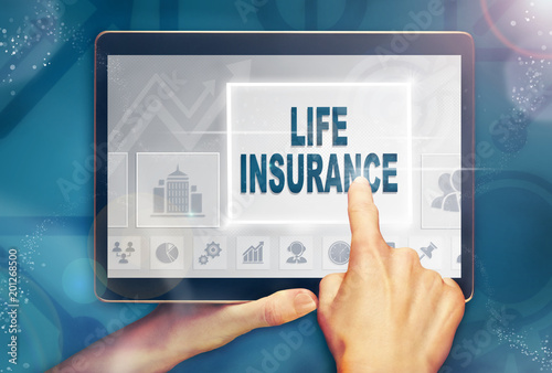 A hand holiding a computer tablet and pressing a Life Insurance business concept. photo