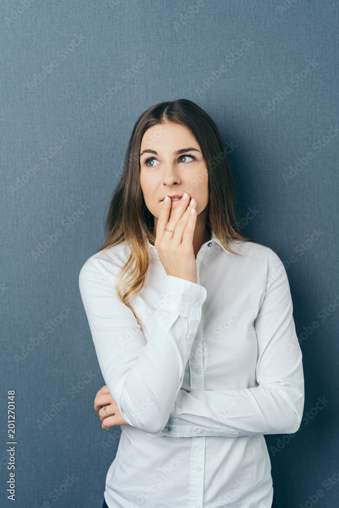 Young thoughtful woman against blue background