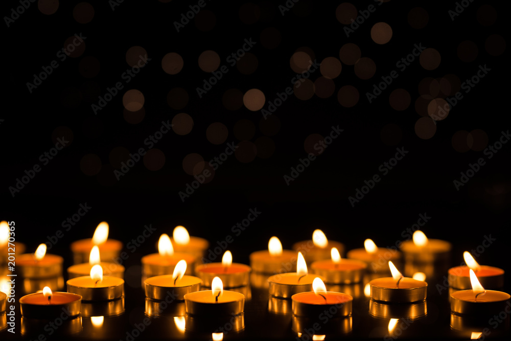 Candles in the dark with reflection and shallow depth of field, with lights in the background Candles in the dark with reflection and shallow depth of field, with lights in the background