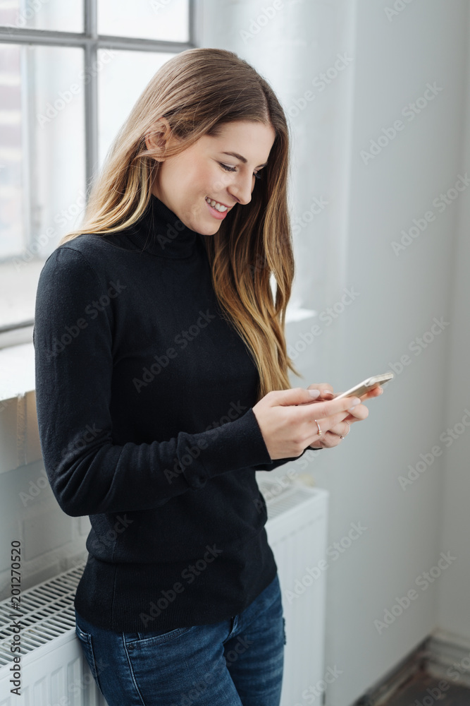Trendy slender young woman texting a message Trendy slender young woman texting a message