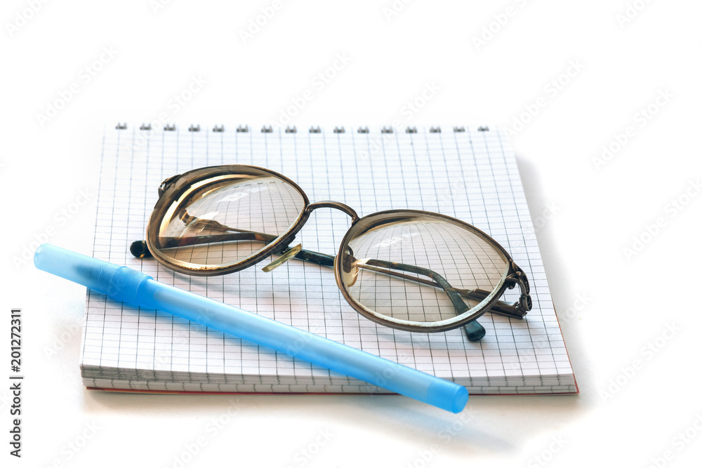 glasses in metal frame, notepad and pen on white background glasses in metal frame, notepad and pen on white background