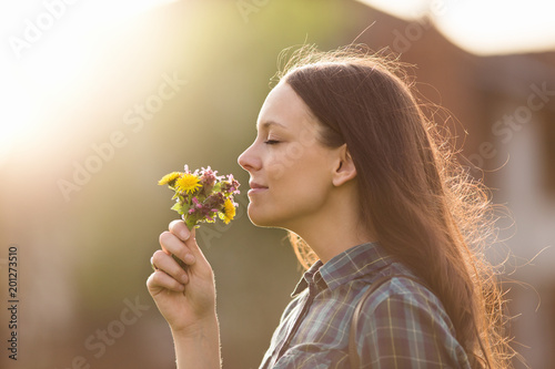 Pretty woman smelling flowers