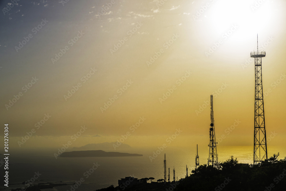 Silhouettes of telecommunications towers at sunset