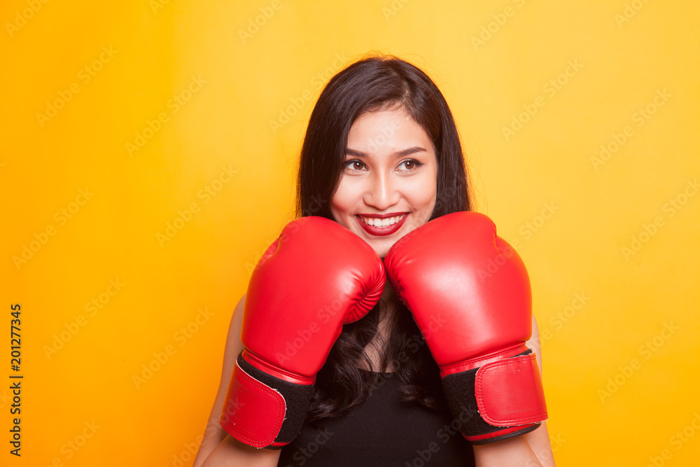Unhappy Asian woman thumbs down with dumbbells. Unhappy Asian woman thumbs down with dumbbells.