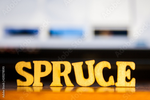 The word 'spruce' made of wooden letters. wood inscription on table