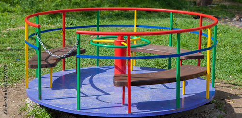 Children's iron carousel. Children's playground. Swing, carousel and slide photo