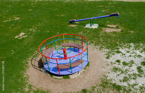 Children's iron carousel. Children's playground. Swing, carousel and slide photo