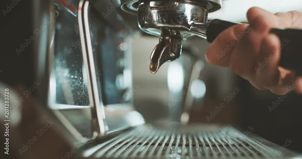Barista at work in the cafe, close-up. Coffee making process in professional coffee machine.