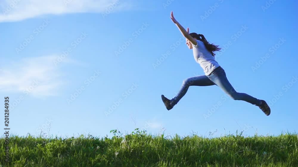 Happy girl jumping on green grass hill Happy girl jumping on green grass hill