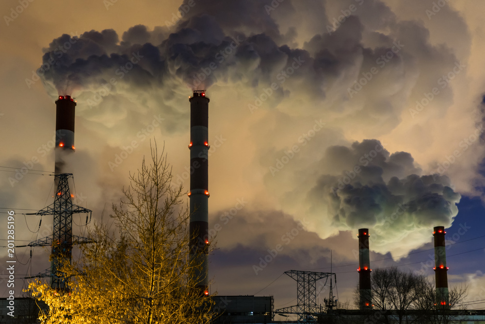 power plant emitting smoke and vapor in cold weather, day and night