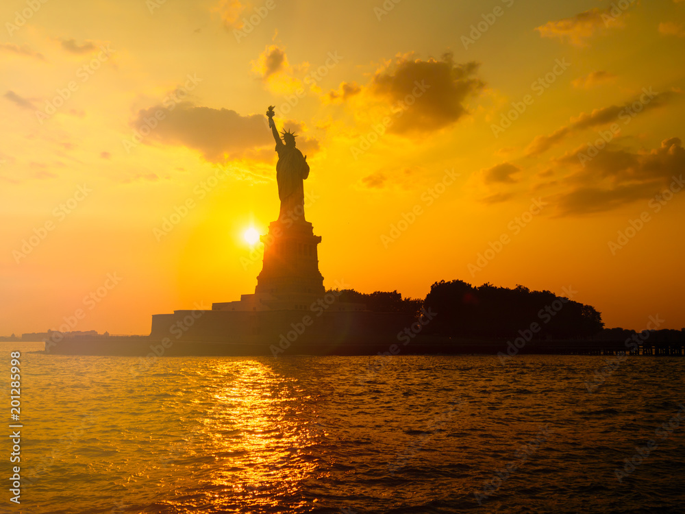 Naklejka premium Statua Wolności w Nowym Jorku o zachodzie słońca