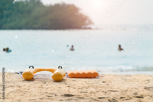 summer beach swim ring inner tube on the beach with blurred swimmer on the sea. tropical beach landscape for background or wallpaper.