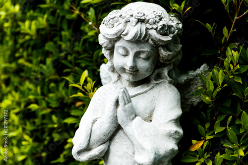 Statues of Guardian angels in green garden © Kampol