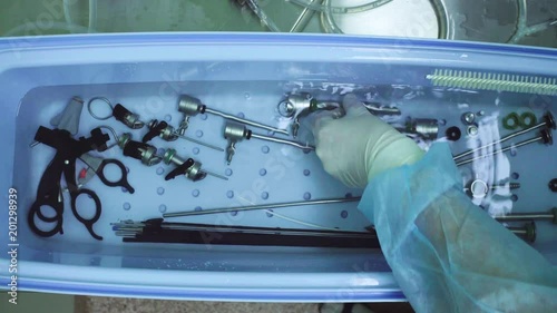 Close up hands of the nurse washing medical instrument after operation