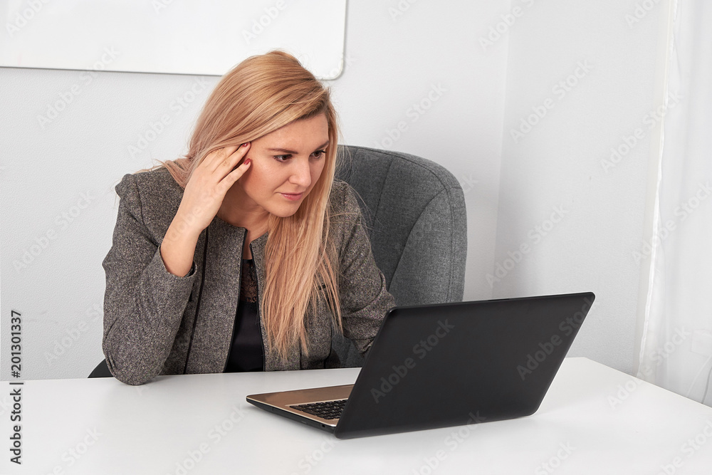 Beautiful business woman is working behind laptop at office Beautiful business woman is working behind laptop at office