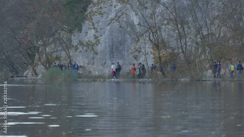 People walking by a lake in Plitvice National Park People walking by a lake in Plitvice National Park