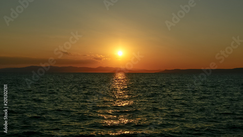Fototapeta Naklejka Na Ścianę i Meble -  Sunset at sea, against islands