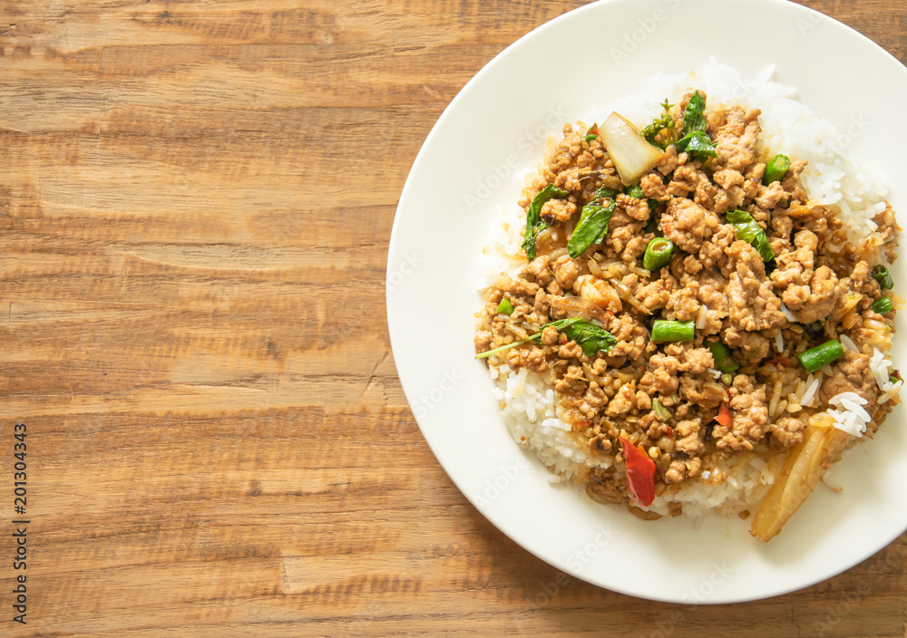Thai food, Stir-fried pork with basil leaves on wooden background with space for text