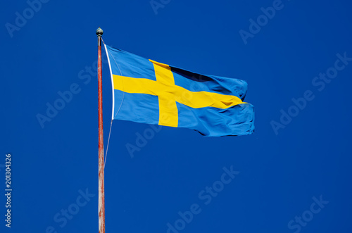 Flag of Sweden against the blue sky, national patriotic background