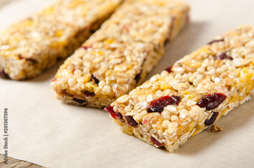 Granola bar with nuts, berries and oat flakes on a white background. Healthy food. Diet and vegetarian dish