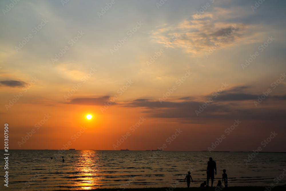 man and children play on beach and sunset