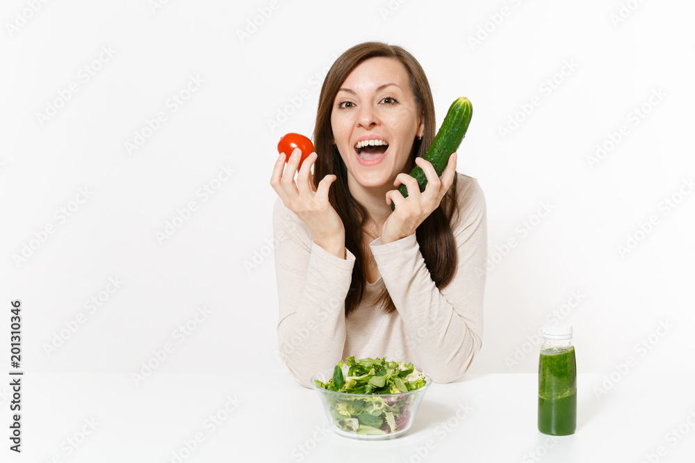 Woman at table with green detox smoothies, fresh salad in glass bowl, tomato, cucumber isolated on white background. Proper nutrition, vegetarian food, healthy lifestyle, dieting concept. Copy space. Woman at table with green detox smoothies, fresh salad in glass bowl, tomato, cucumber isolated on white background. Proper nutrition, vegetarian food, healthy lifestyle, dieting concept. Copy space.