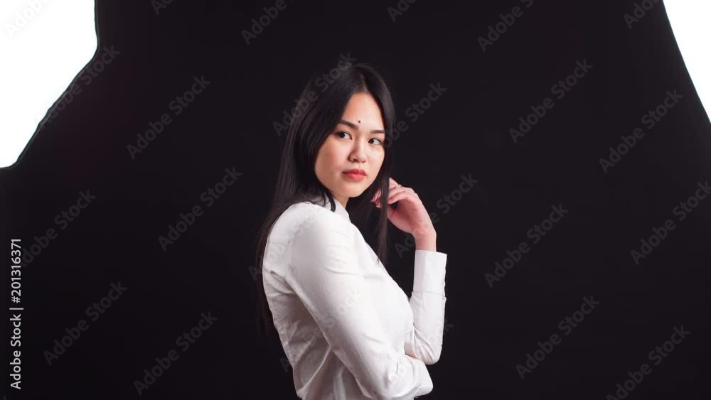 Beautiful asian woman with long hair posing in studio on black background. Beautiful asian woman with long hair posing in studio on black background.