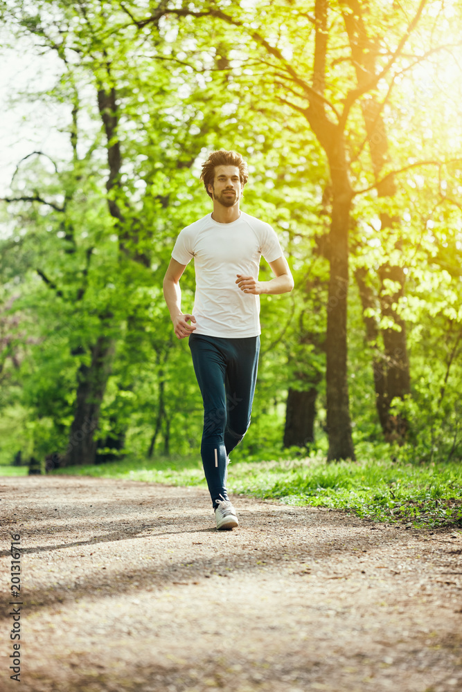 Young man is jogging in park.